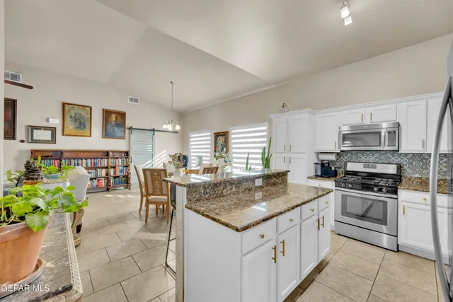a kitchen with stainless steel appliances granite countertop a stove top oven a sink dishwasher and cabinets