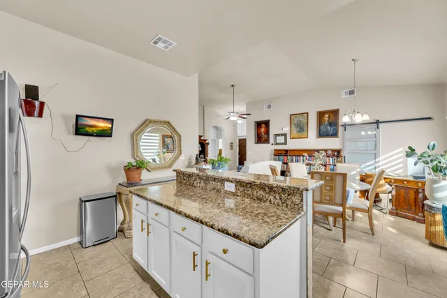 a room with kitchen island granite countertop furniture and a chandelier