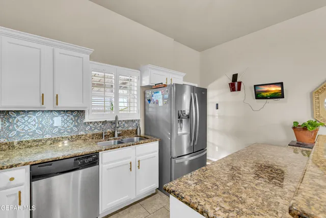 a kitchen with stainless steel appliances granite countertop a refrigerator sink and stove