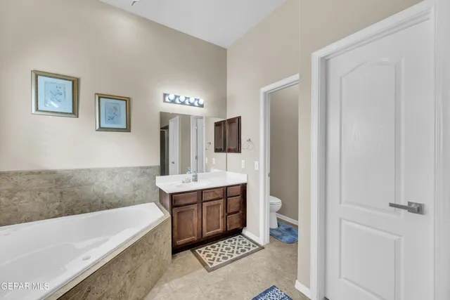 a bathroom with a tub a sink and a large mirror