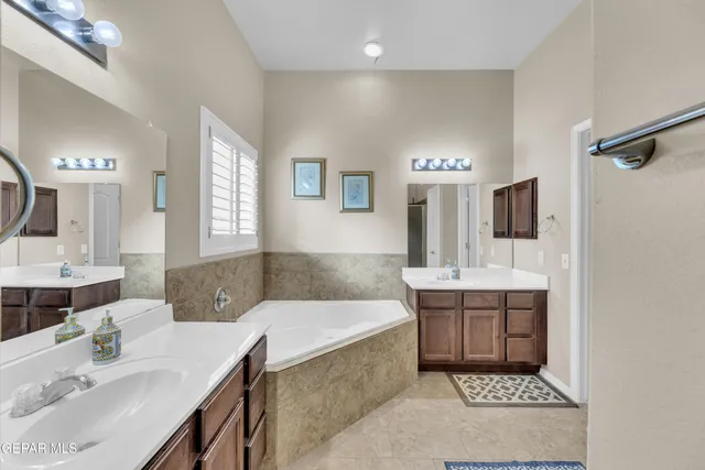 a spacious bathroom with a tub sink and mirror