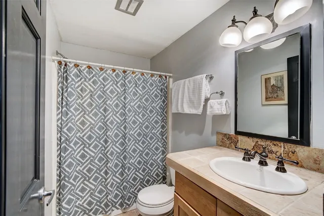 a bathroom with a sink toilet and mirror