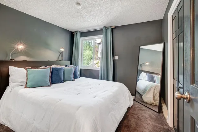 a bedroom with a large bed and a chandelier