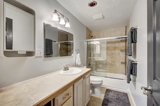 a bathroom with a granite countertop sink toilet and shower