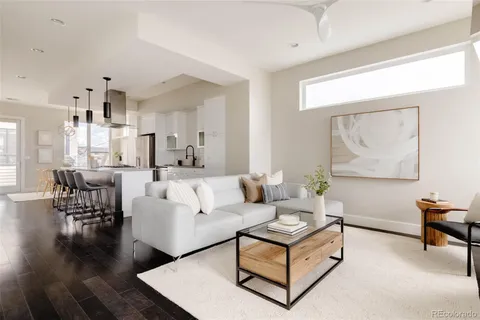 a living room with furniture wooden floor and a large window