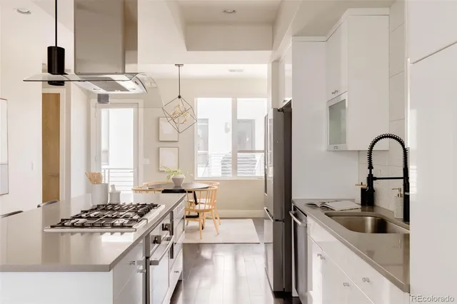 a kitchen with stainless steel appliances a stove a sink and a microwave