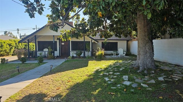 a view of a house with backyard and a tree