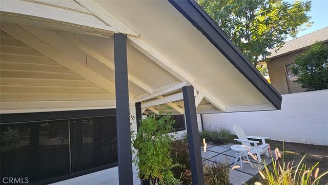 a view of a house with backyard and sitting area