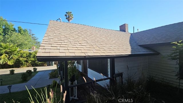 a front view of a house with swimming pool and a patio