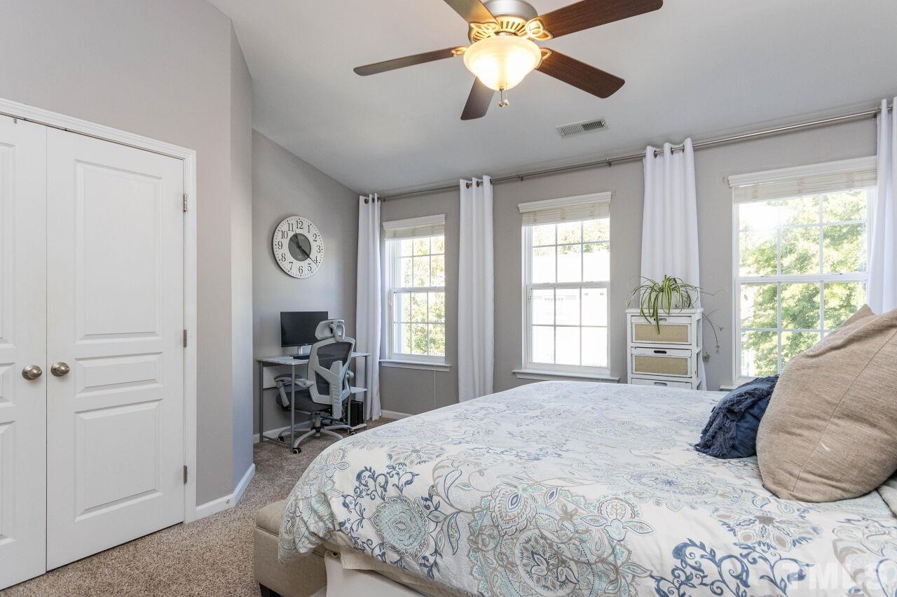 7863 Spungold Street Raleigh, NC 27617 - Photo 17 of 34 a bedroom with a bed and a large window