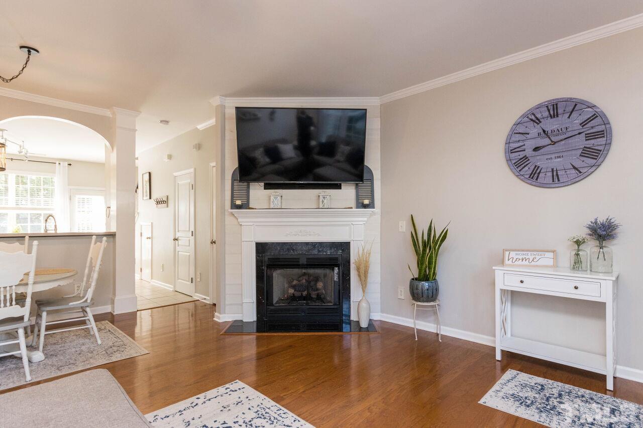 7863 Spungold Street Raleigh, NC 27617 - Photo 6 of 34 a living room with furniture a flat screen tv and a fireplace