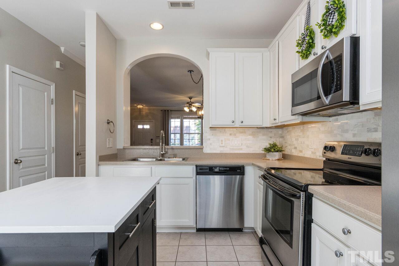 7863 Spungold Street Raleigh, NC 27617 - Photo 9 of 34 a kitchen with stainless steel appliances a stove microwave and sink