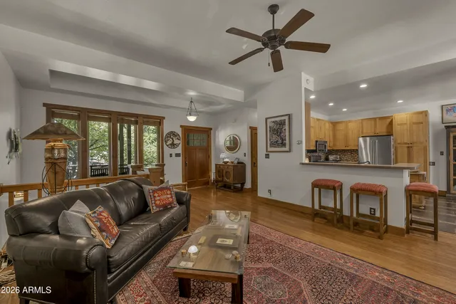 a living room with furniture kitchen view and a window