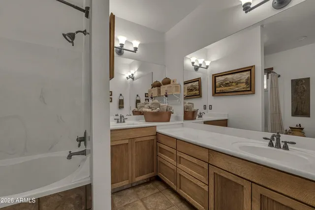 a bathroom with a sink double vanity granite tub shower and a mirror