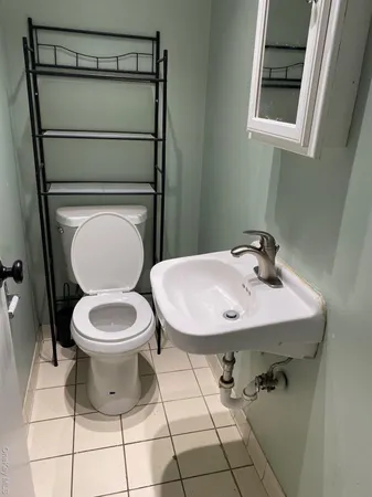 a bathroom with a toilet a sink and a mirror