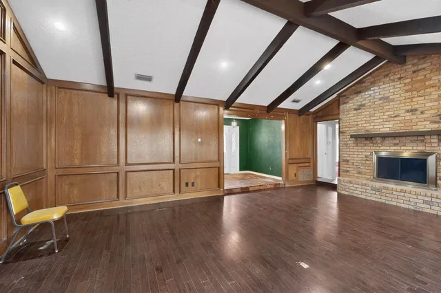an empty room with wooden floor and fireplace