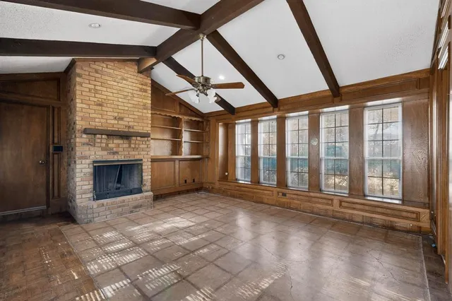 a view of an empty room with a fireplace and a window