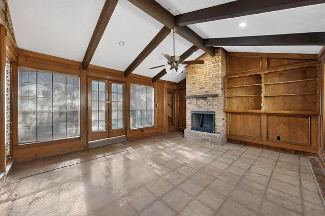 a view of an empty room with a fireplace and a window