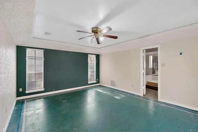 a view of an empty room with a window and a kitchen