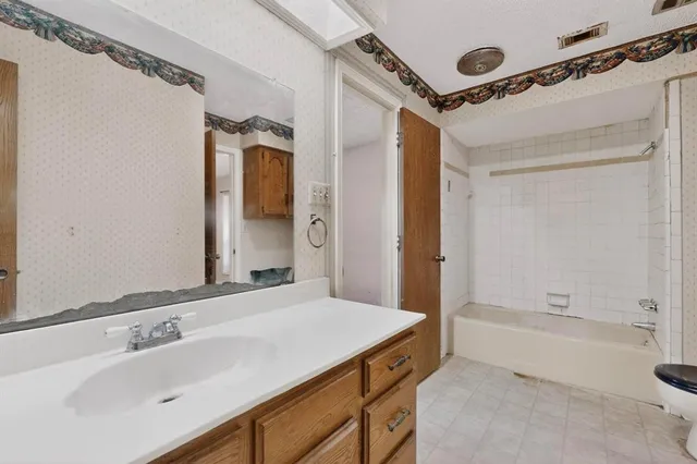 a bathroom with a tub sink shower and mirror