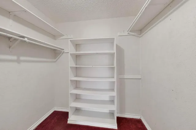 a view of walk in closet with empty racks