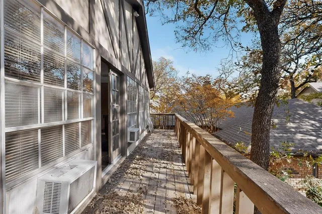 a balcony with view of trees in front of house