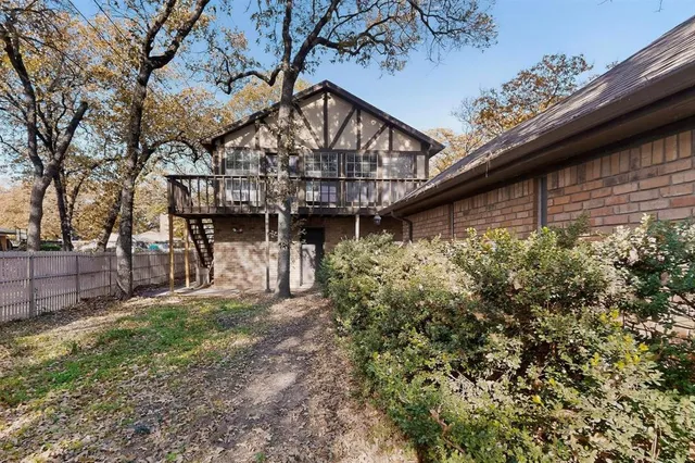 a view of a house with a small yard and wooden fence