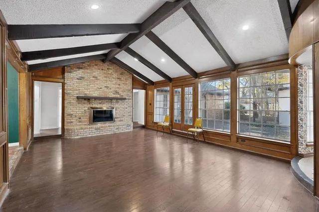 an empty room with wooden floor and fireplace