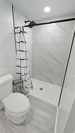 a bathroom with a toilet and a shower