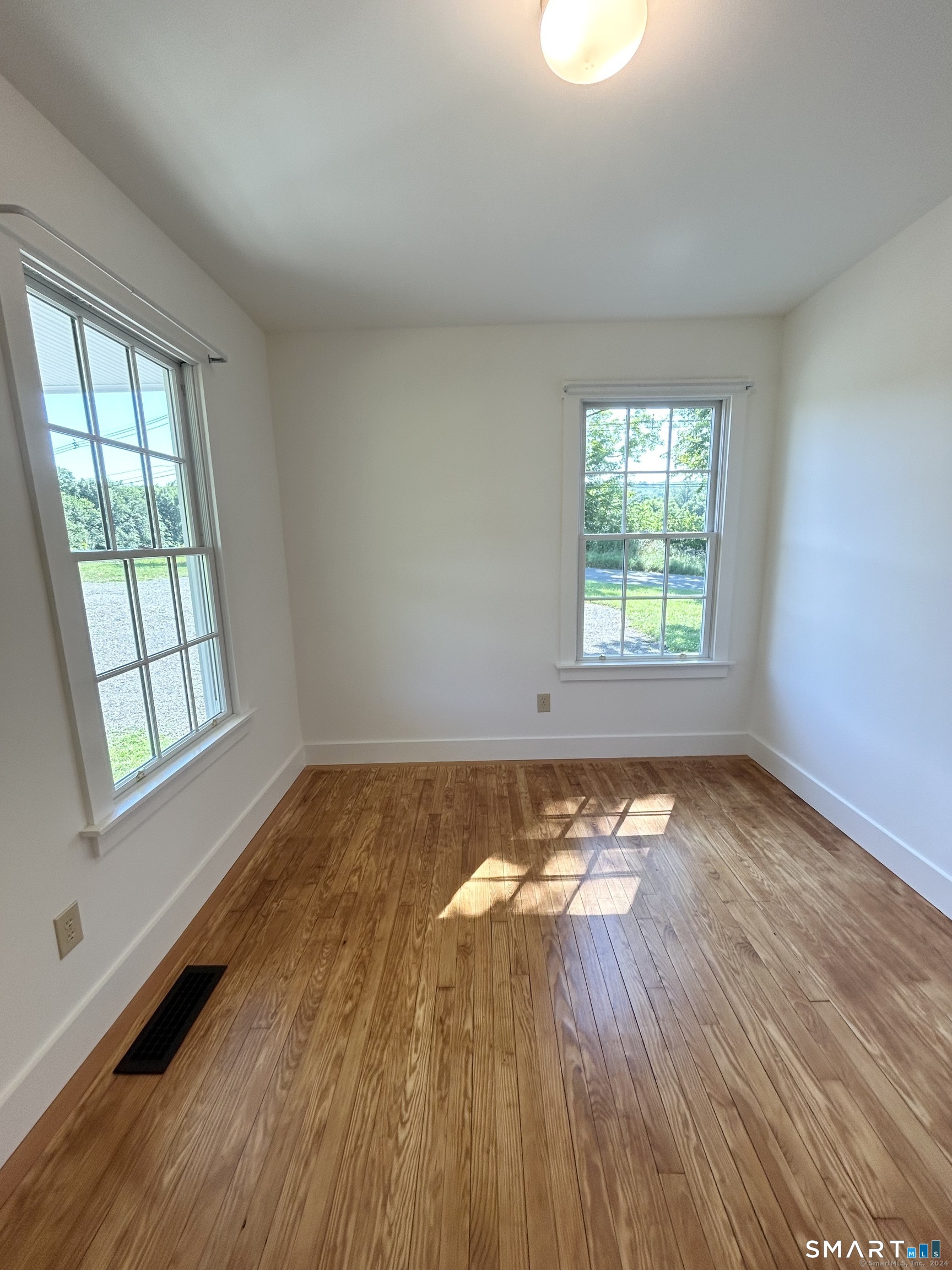 533 Weekeepeemee Road Woodbury, CT 06798 - Photo 11 of 17 an empty room with wooden floor and windows