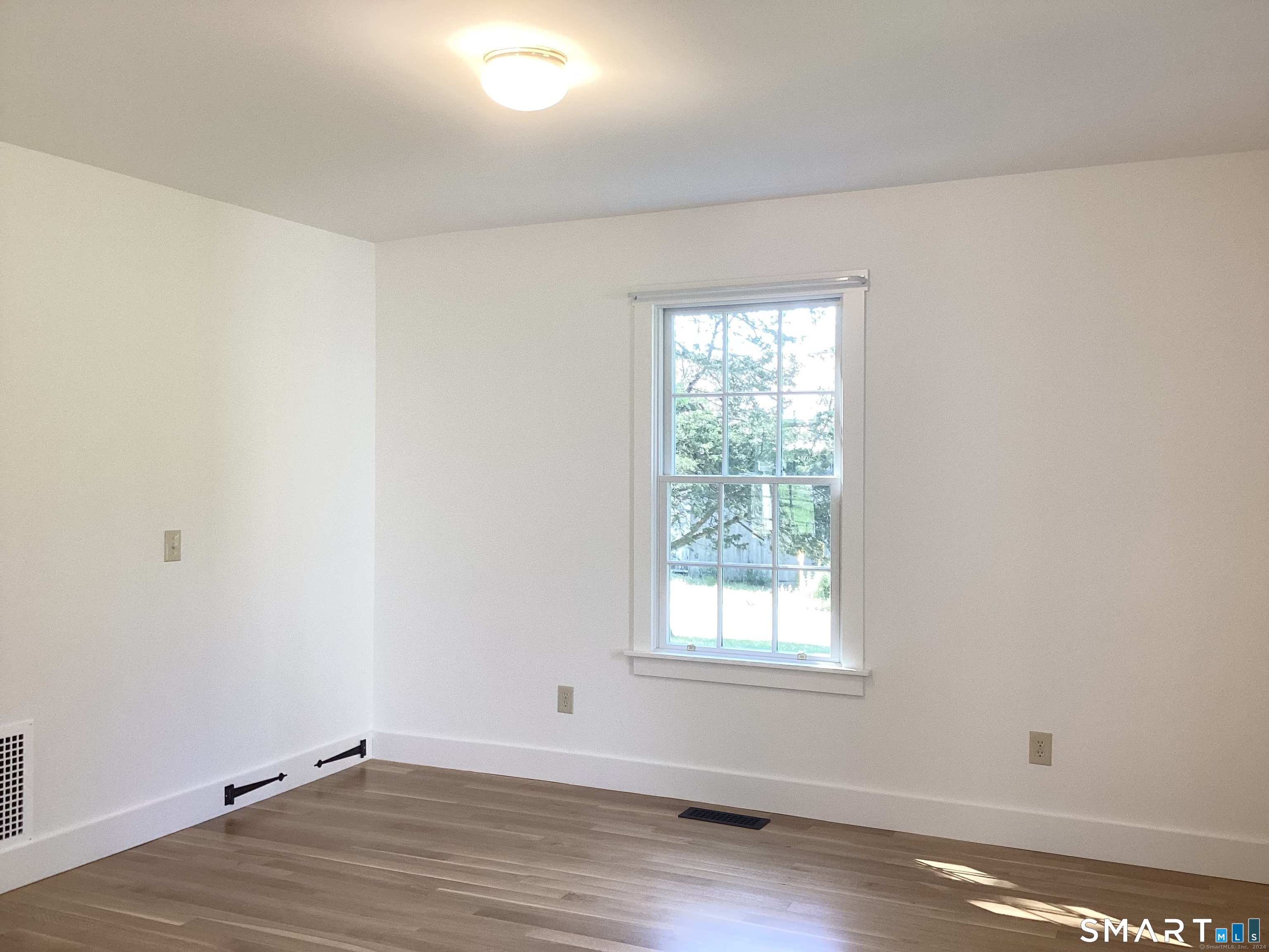 533 Weekeepeemee Road Woodbury, CT 06798 - Photo 8 of 17 an empty room with wooden floor and window