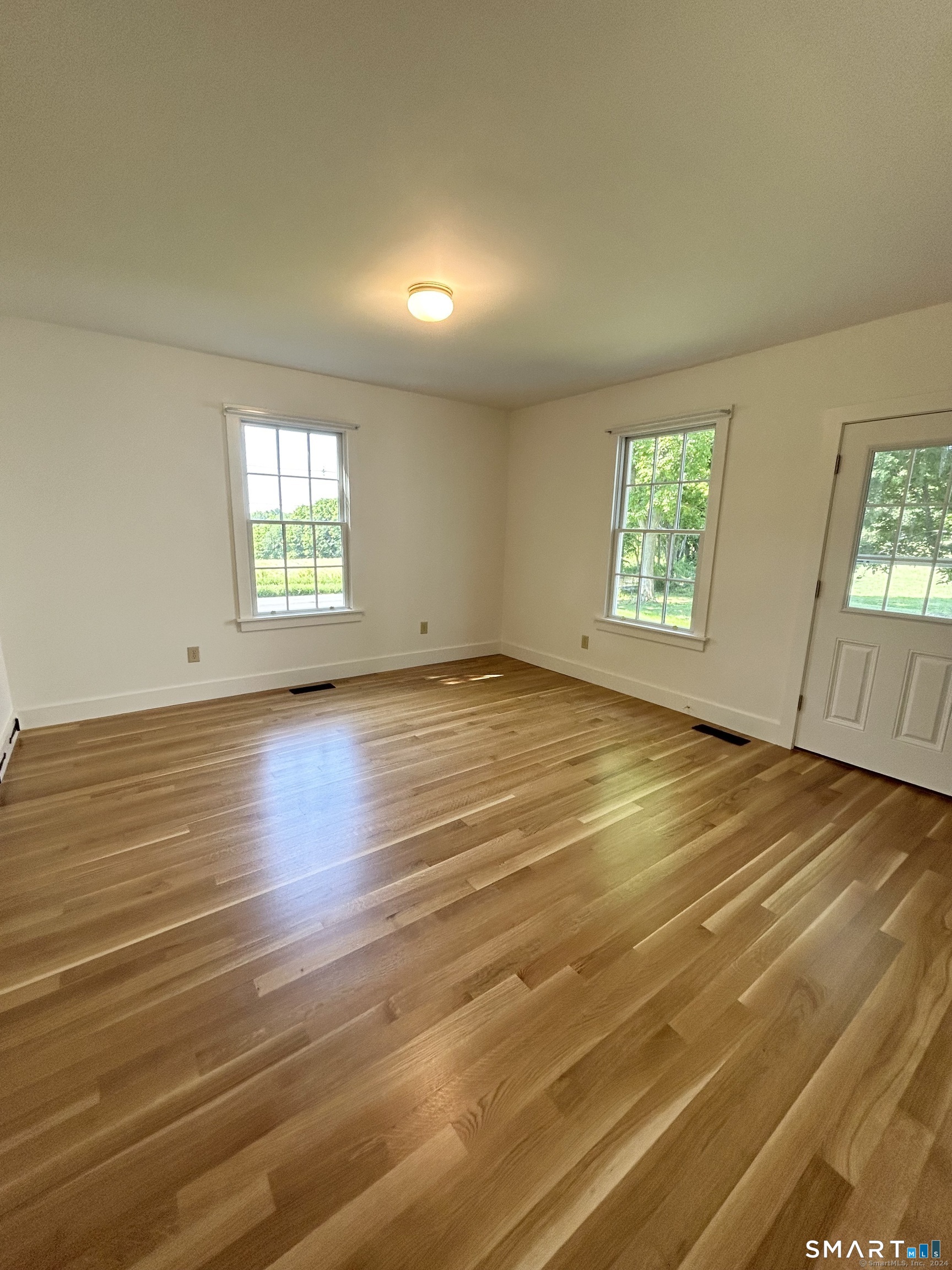 533 Weekeepeemee Road Woodbury, CT 06798 - Photo 10 of 17 an empty room with wooden floor and windows