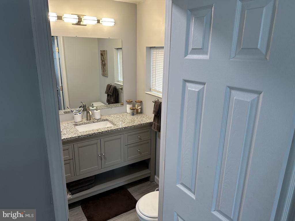 7703 Dover Road Glen Burnie, MD 21060 - Photo 14 of 25 a bathroom with a sink vanity granite and toilet