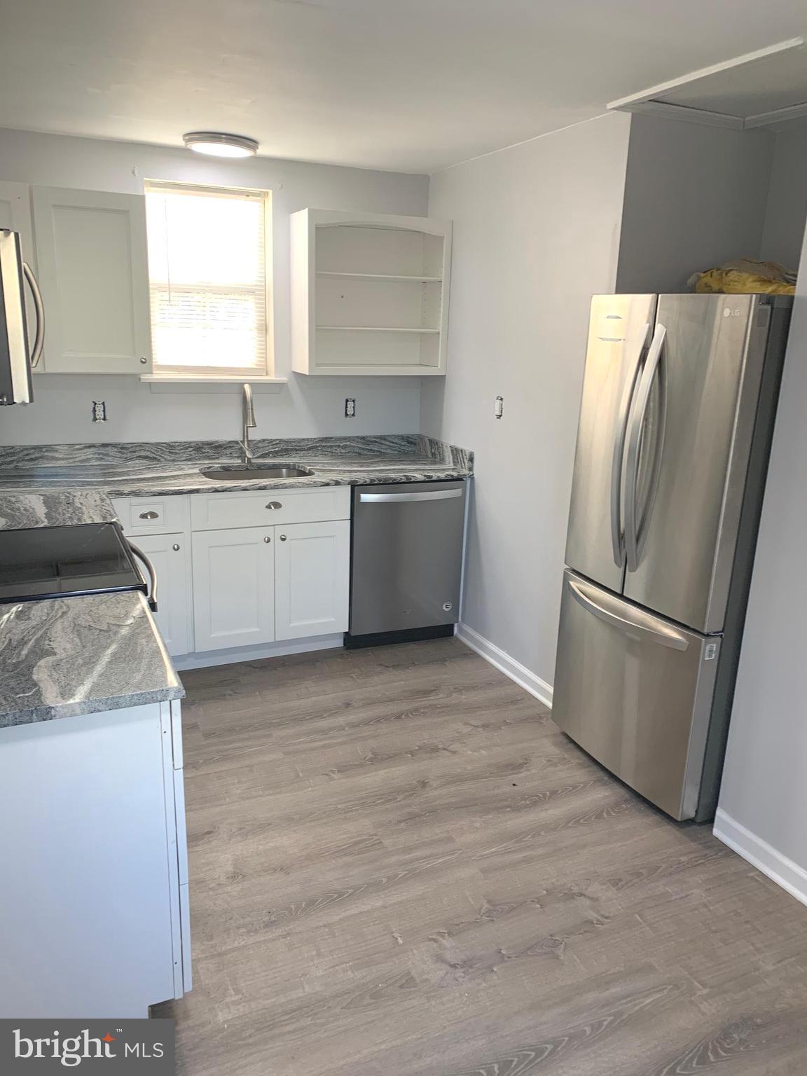 7703 Dover Road Glen Burnie, MD 21060 - Photo 2 of 25 a kitchen with a sink refrigerator and microwave