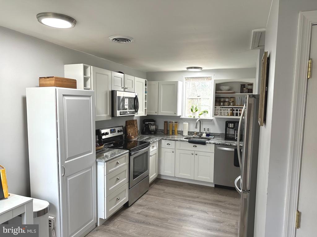 7703 Dover Road Glen Burnie, MD 21060 - Photo 6 of 25 a kitchen with stainless steel appliances granite countertop a refrigerator stove and sink