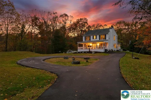 a view of a house with a yard and a large tree