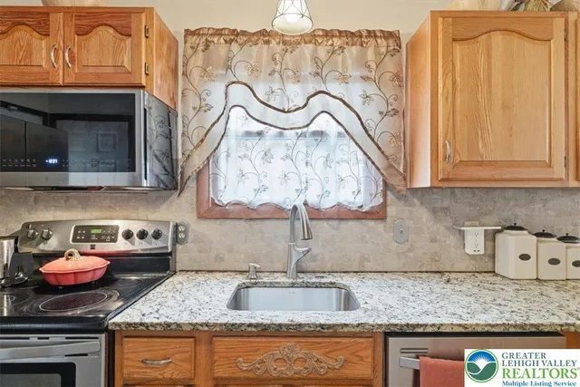 a kitchen with granite countertop a sink and a stove