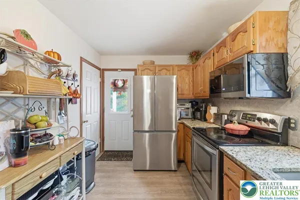 a kitchen with stainless steel appliances granite countertop a refrigerator and a stove