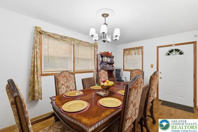 a dining room with furniture a chandelier and window