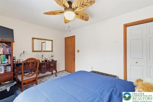 a bedroom with furniture and a chandelier fan