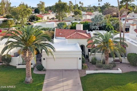 a view of a house with a yard and potted plants