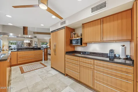 a kitchen with stainless steel appliances kitchen island granite countertop a refrigerator and cabinets