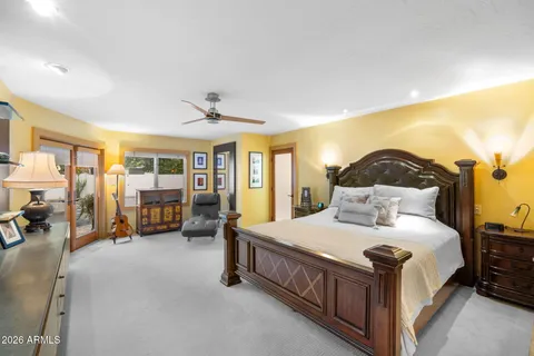 a bedroom with a bed couch and a large window