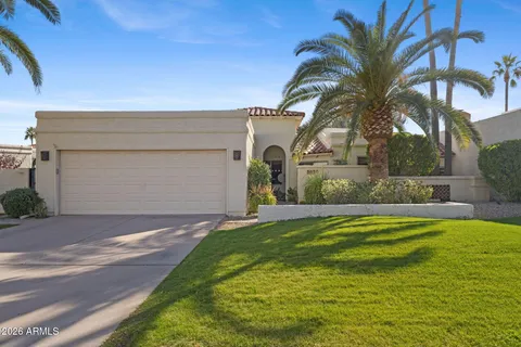 a view of a house with a yard and palm trees