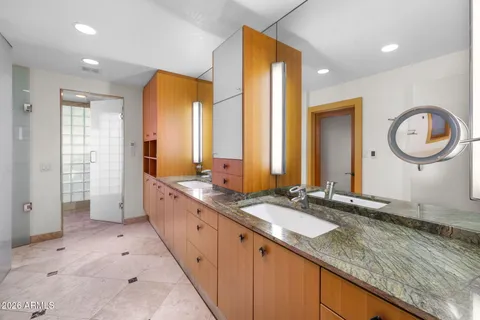a spacious bathroom with a granite countertop sink and a mirror