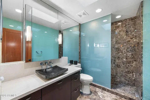 a bathroom with a sink a toilet and shower