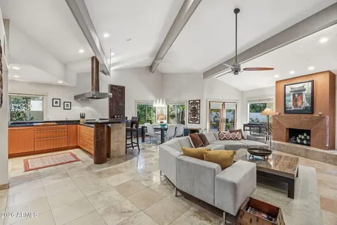 a living room with furniture a fireplace and a chandelier