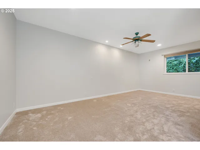 a view of an empty room with a ceiling fan