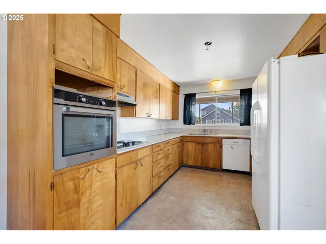 a large kitchen with stainless steel appliances granite countertop a stove a sink and a microwave