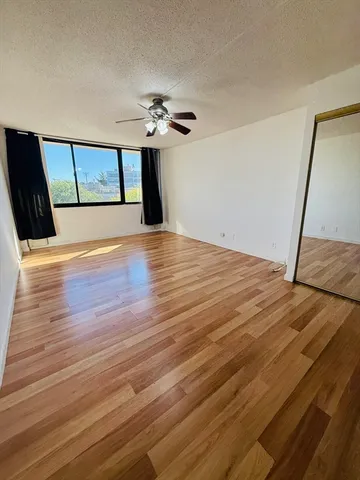 a view of an empty room with wooden floor